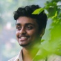A young man looking away with a smile.