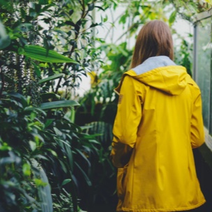 A person in a yellow rain jacket facing away.