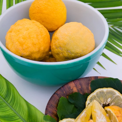 A picture of oranges in bowl and some sliced up on a plate.